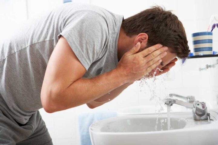 man washing face